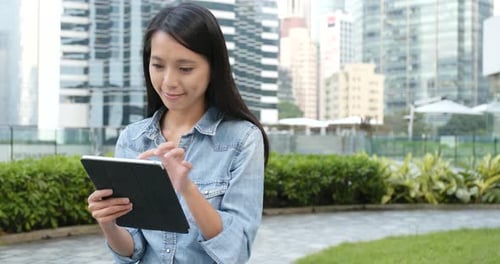 Woman looking at tablet in city