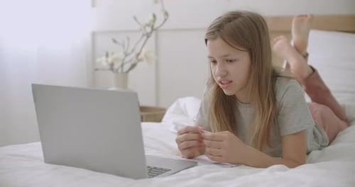 Teen Studying on Laptop in Bedroom