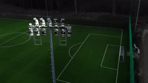 Football Field That Is Lit Up in the Night. Flying Over Illuminated Devices That Illuminate the