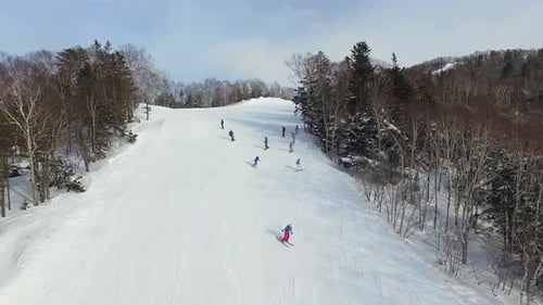 Drone View of a Group of Snowboarders Descending the Ski Slope