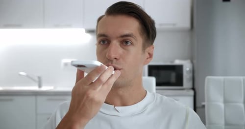 Man Using Speakerphone in Bright Modern Kitchen