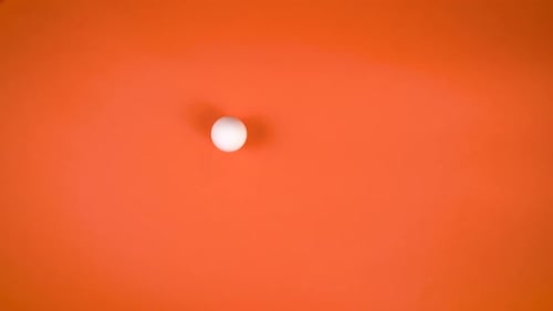 White Egg Spinning On Orange Background