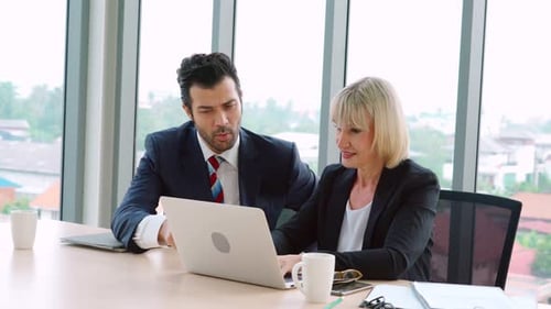 Two Business People Talk Project Strategy at Office