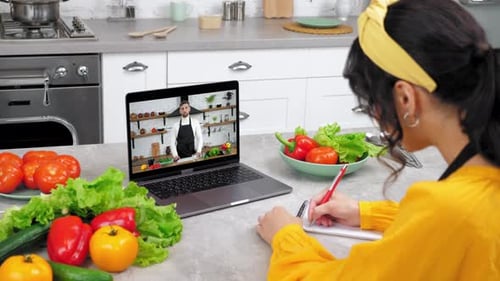 Woman Taking an Online Cooking Class in Kitchen
