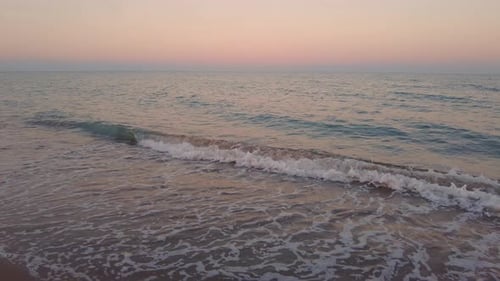 Sunset on an Ocean Beach and Foamy Waves and Colorful Sky Camera Movement