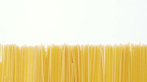 Uncooked Spaghetti Neatly Arranged on White Background