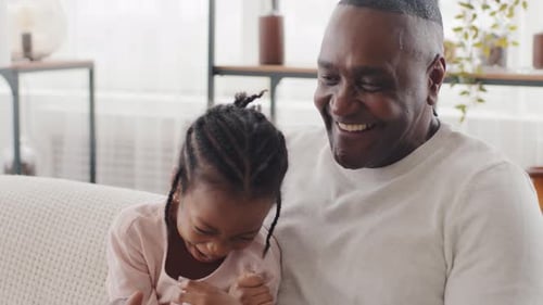 Laughing Girl with Man on Couch Indoors