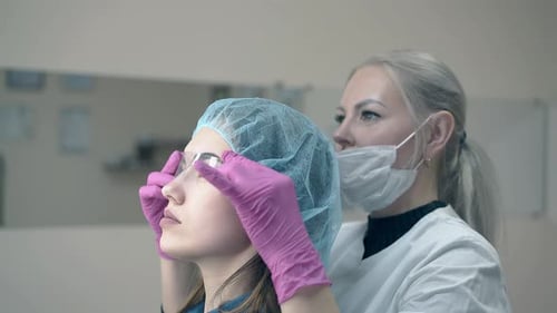 Cosmetologist Shaping Eyebrows in Beauty Clinic