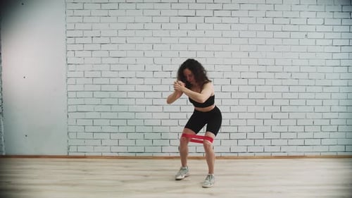 Workout in Sports Studio Young Woman with Curly Hair Training with an Elastic Band