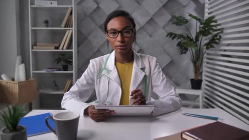 Friendly Doctor Explains Information While Holding Tablet