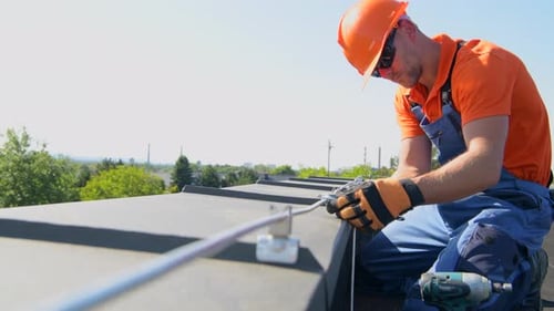 Technician Adjusting Metal Rod of Lightning Protection System on the Top of the Building.