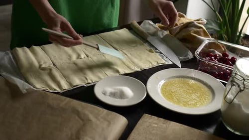Woman Preparing Pastry with Cherries in Kitchen