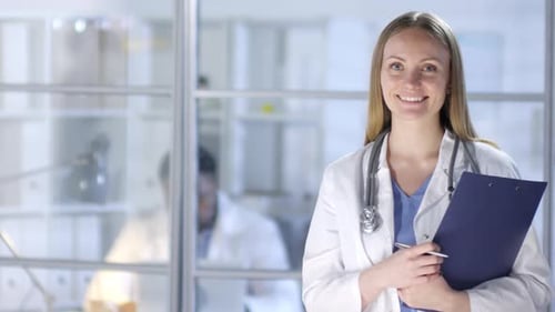 Smiling Medical Professional Holding Clipboard in Hospital