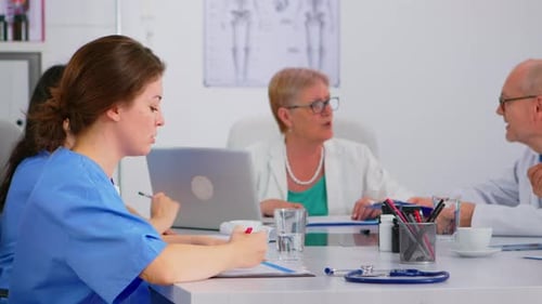 Medical Professionals Meeting at Conference Table in Bright Office