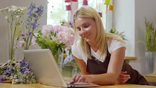 Woman Uses Laptop Amongst Flowers