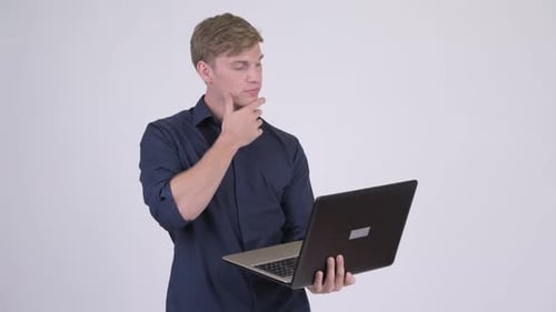 Young Adult Using Laptop Computer and Smiling