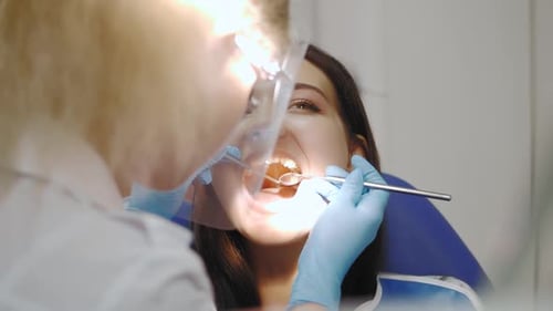 Dentist Examining a Patient's Teeth in the Dentist Office