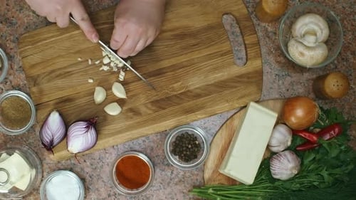Top View of Cook Chopping Garlic Cloves