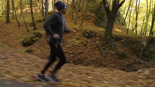 Active Man Running Through Autumn Forest