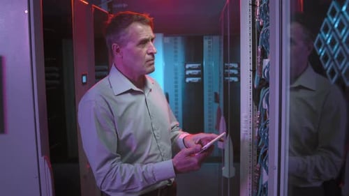 Male Technician Checking Servers in Data Center
