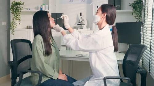 Asian professional woman doctor using a rapid antigen quick swab to test for COVID-19 due pandemic.