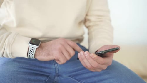 Man Using Smart Phone and Watch Indoors