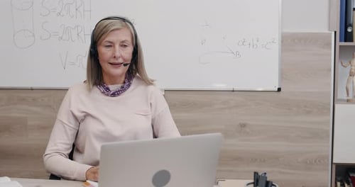 Woman Teaches Online Class Using Laptop and Headset