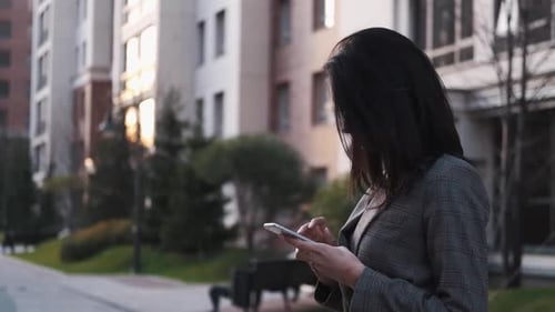 Woman Using Smartphone in City Street