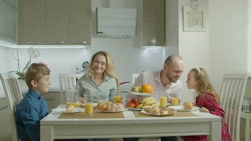 Family Eating Breakfast Together at Kitchen Table
