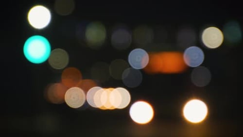 Blurred Headlights of Moving Cars and Traffic Lights in the City at Night