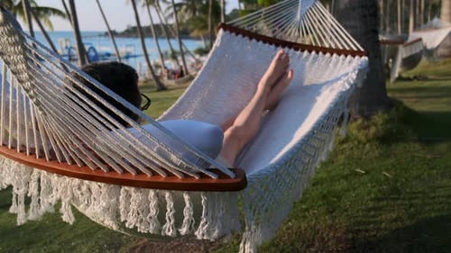 Person Relaxing in Hammock on Tropical Beach