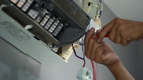 Hands Repairing an Air Conditioner with Screwdriver