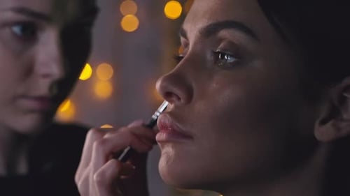 Makeup Artist Applying Cosmetics to a Young Woman