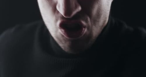 Man Shouting Aggressively in Dark, Dramatic Close-Up