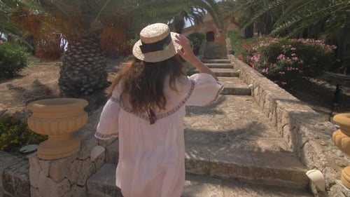 Beautiful woman running up the stairs near luxury villa in Italy