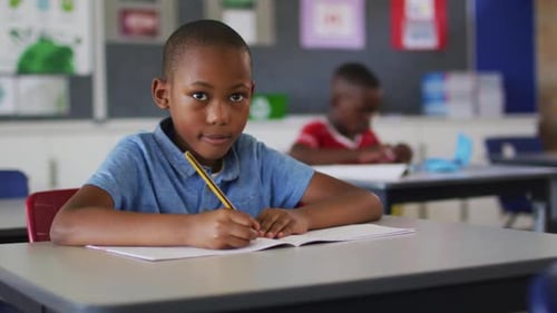 Young Student Writing in a Classroom