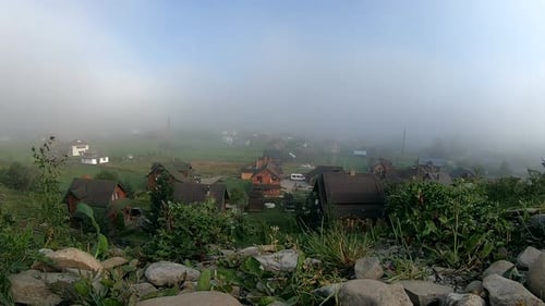 Fog Rolls Over Mountain Village Landscape