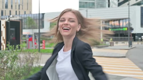 Businesswoman Dancing in Joy While Walking on the Street