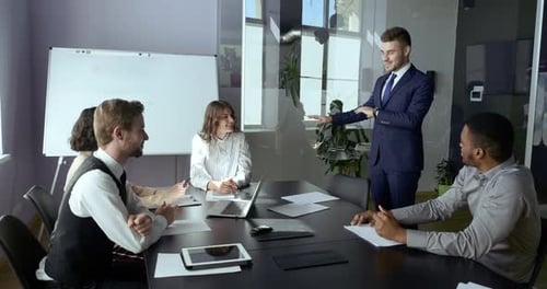 Young Adult Business Man Leader Teacher Stands in Office Speaks Report at Meeting in Office with