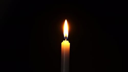 Candle Flame Burning Brightly on Black Background