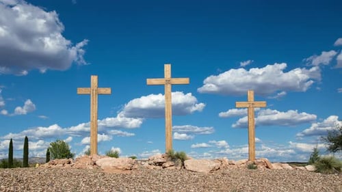 Three Wooden Crosses on a Hill Under Blue Sky