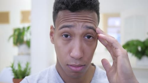 Young Man Experiencing Headache and Rubbing Temples