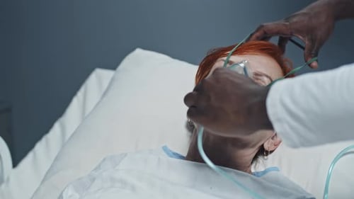 Doctor Applies Oxygen Mask to Female Patient