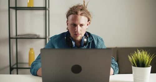 Young Adult Man Using Laptop at Home