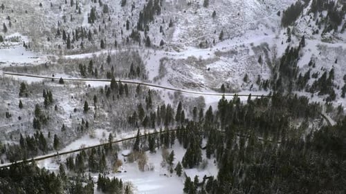 Aerial view of road winding up winter landscape in mountains