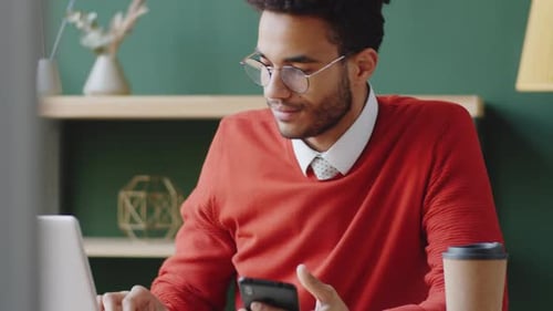 Young Mixed Race Man Messaging on Smartphone in Office