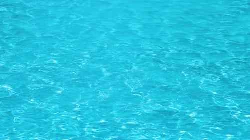Closeup Surface of Blue Clear Water with Small Ripple Waves in Swimming Pool