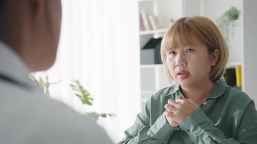 Young Asian female doctor is delivering great news talk results with girl patient hospital