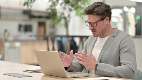 Sad Middle Aged Man Having Failure on Laptop in Office