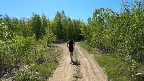Unrecognizable Sportsman Running Near Grove, Tracking Shot of Anonymous Male Athlete Running on Path